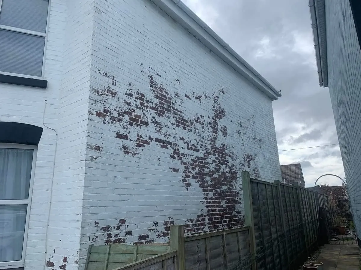 Peeling paint on a brick wall before redecoration in Tavistock
